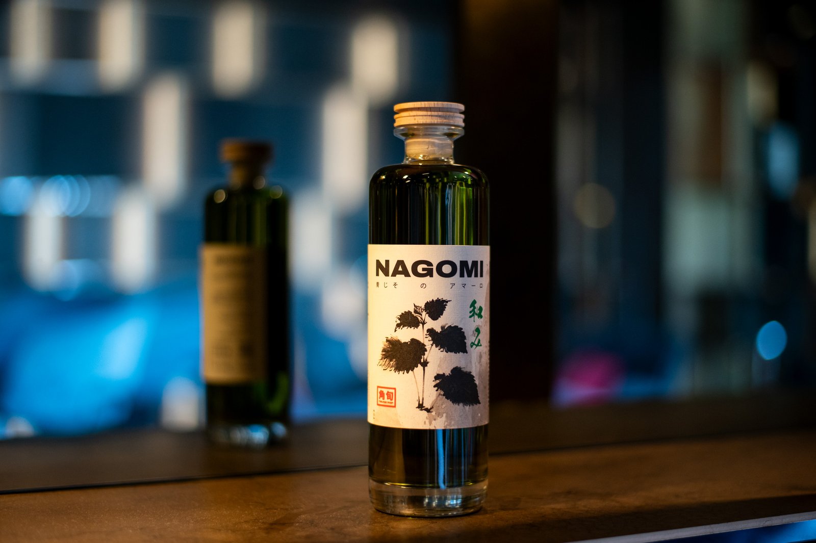 NAGOMI — Bottiglia sul bancone con luci colorate